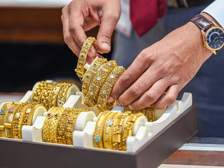 Gold bars with a backdrop of fluctuating financial graphs