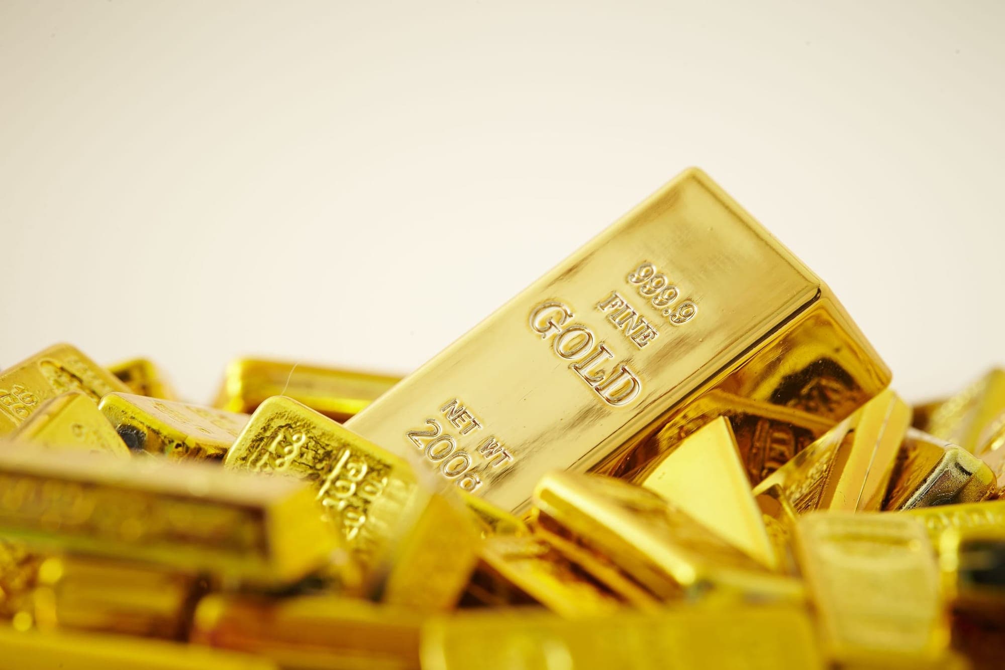 Gold bars with fluctuating price graphs and geopolitical maps