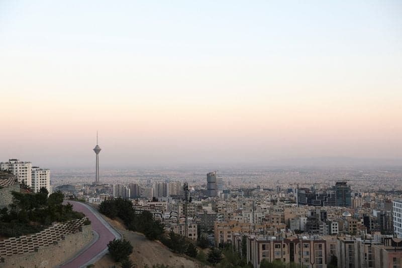US and Iran flags with a backdrop of economic and nuclear symbols