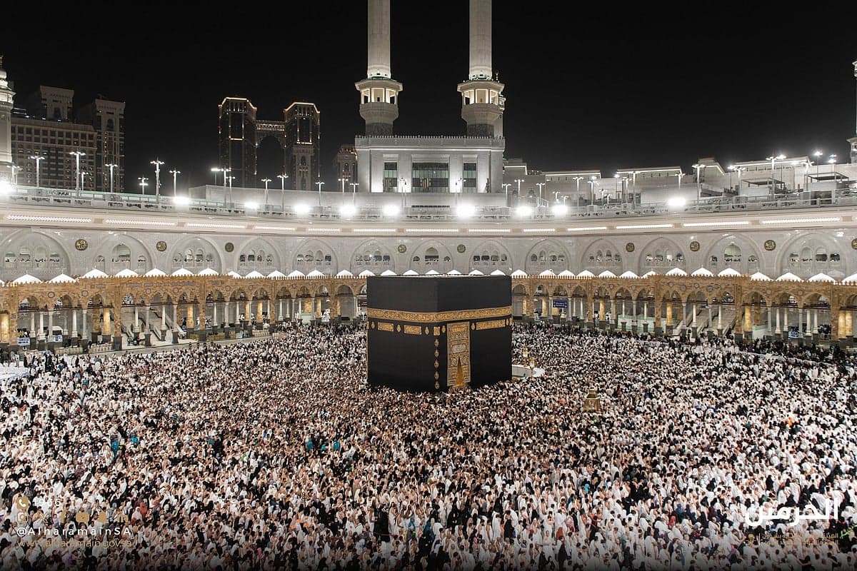Saudi Arabia's Ministry of Hajj and Umrah building with pilgrims in the foreground.