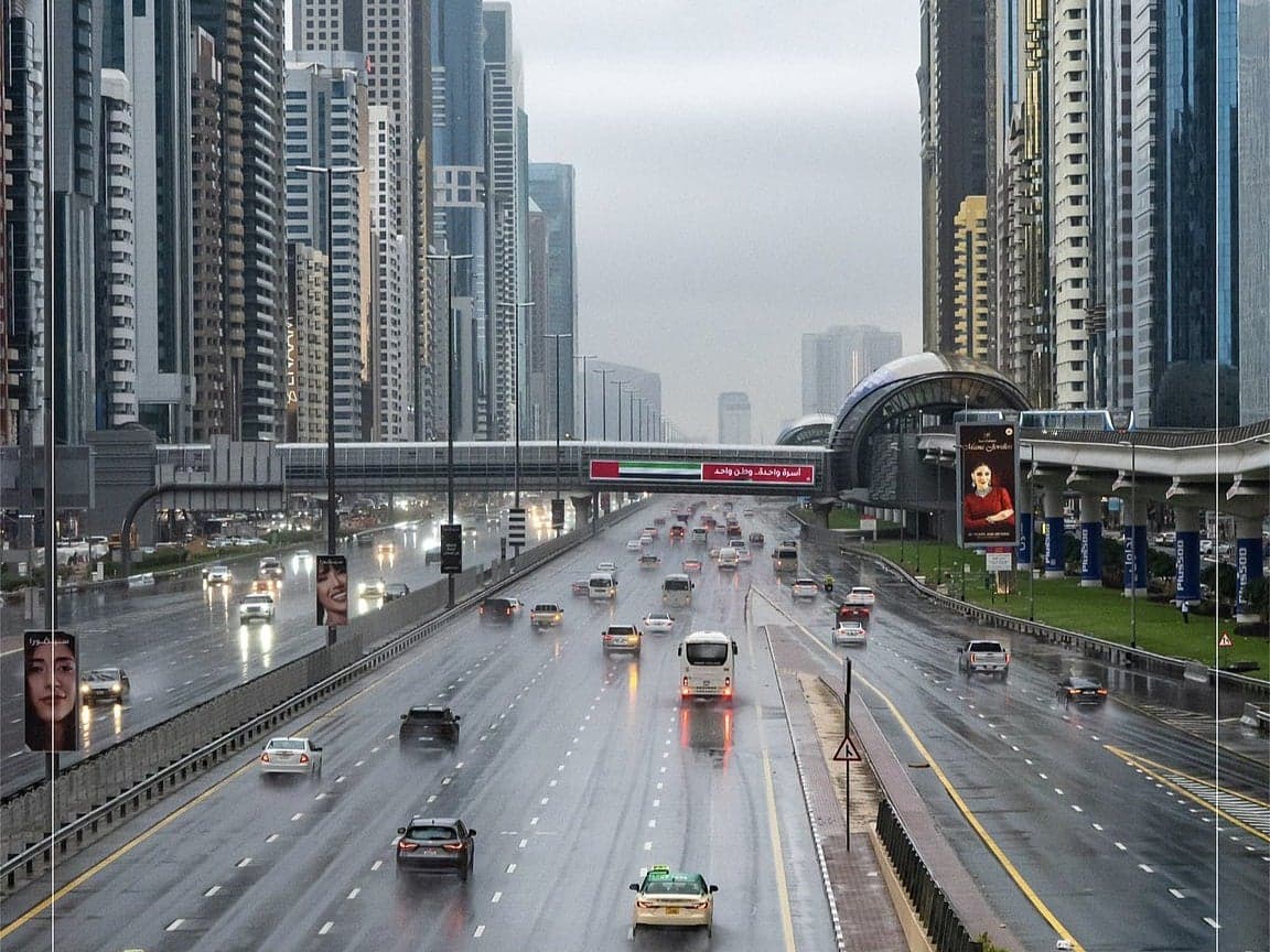 A dramatic image depicting the extreme heat in the UAE with a temperature gauge nearing 50°C.