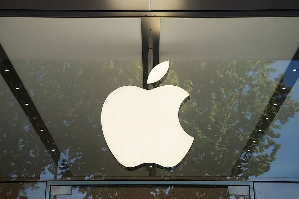 Apple logo with a backdrop of stock market graphs