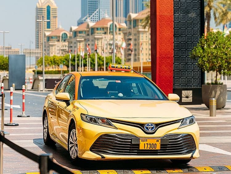 Dubai Taxi Company logo with a taxi in the background