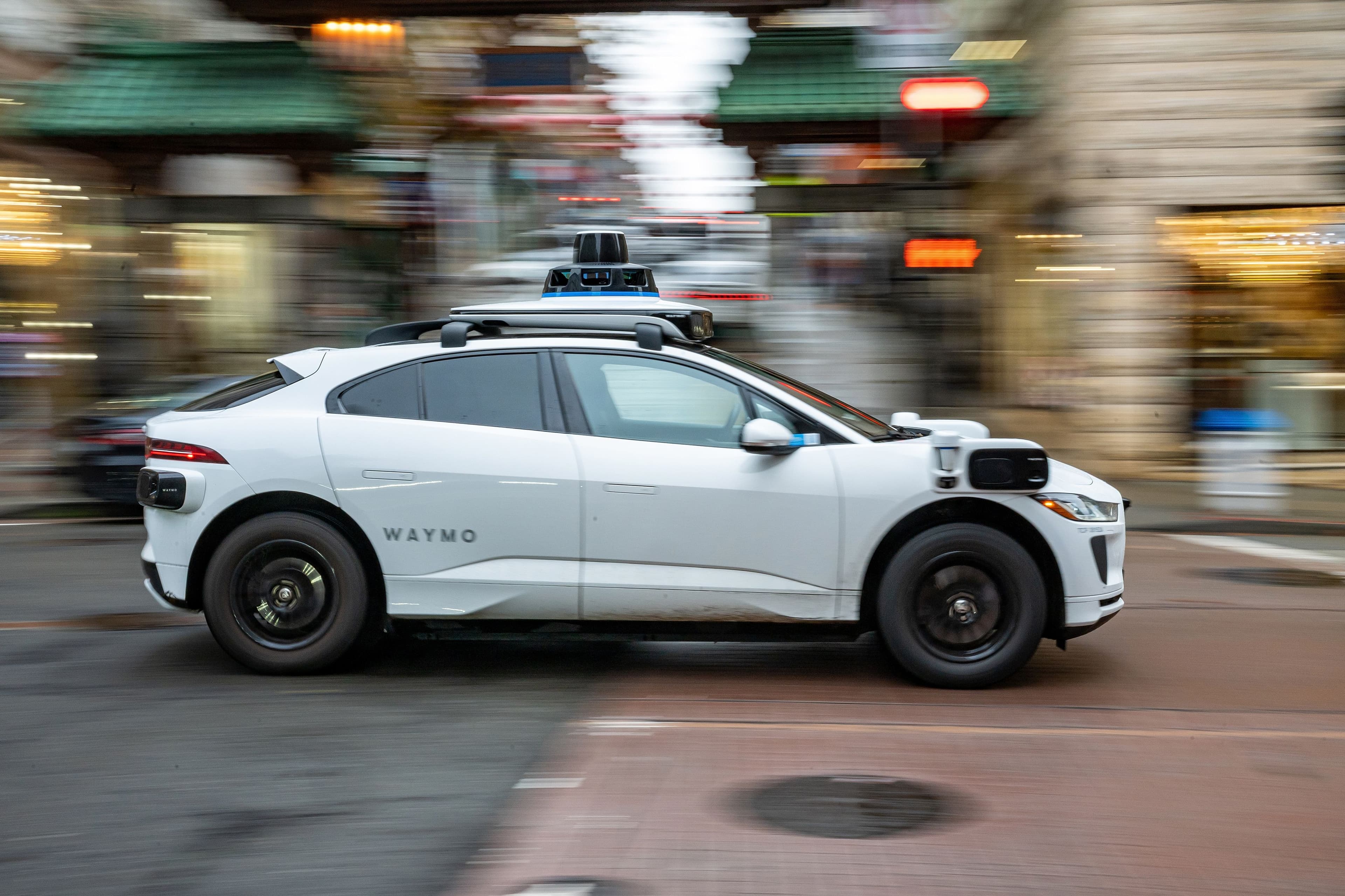 Waymo robotaxi on a city street with construction signs