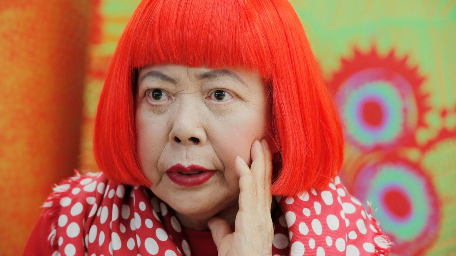 A portrait of Yayoi Kusama surrounded by her signature polka dot art, reflecting her influence on contemporary art.