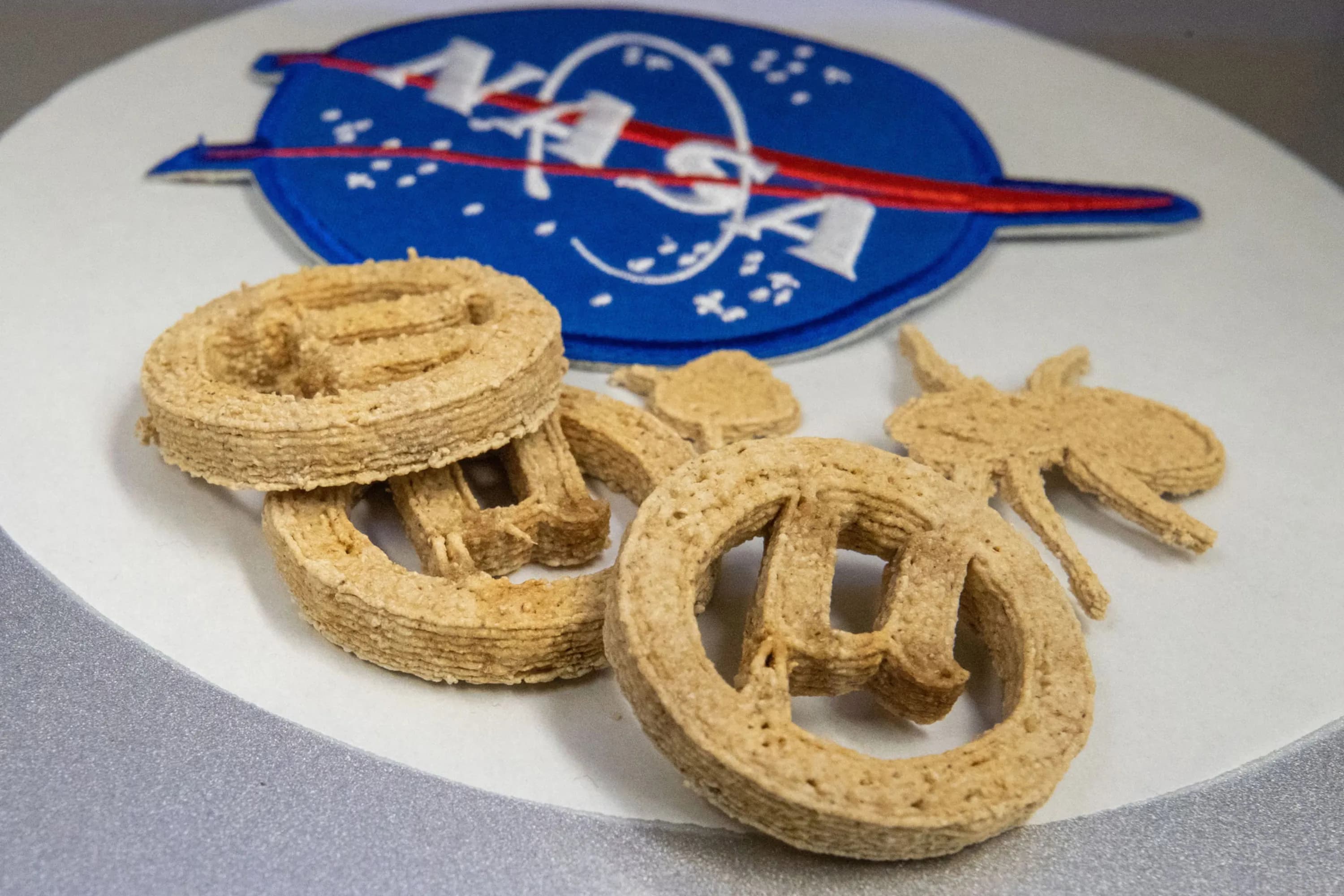 Infographic showing the process of making 3D-printed cookies from recycled plastic and agricultural waste.