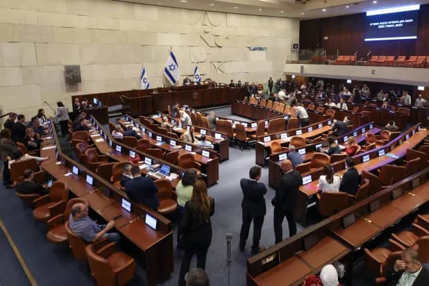 Israeli Knesset building with flags flying, symbolizing political change.