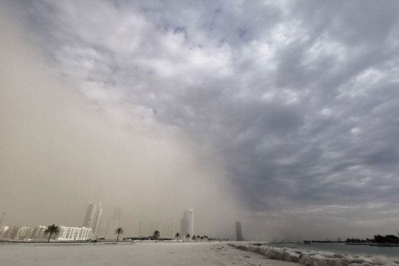 A scenic view of the UAE coastline with rough sea conditions and dusty skies.