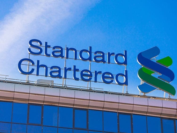Infographic showing Standard Chartered's job cuts and projected income increase due to AI automation.