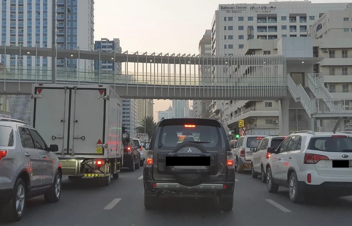 Sharjah City skyline with parking signs indicating new hours