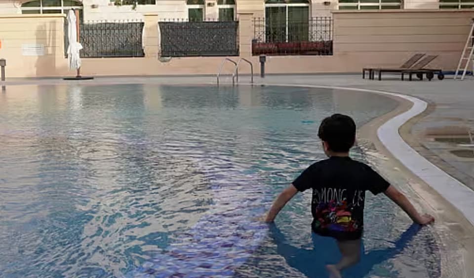 Parents supervising children at a pool during summer