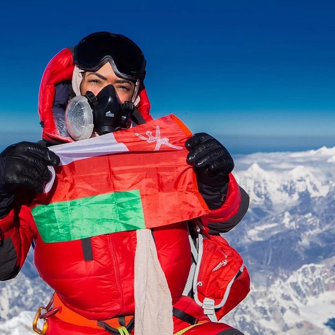 Nadhira Al Harthy climbing with a mountain backdrop