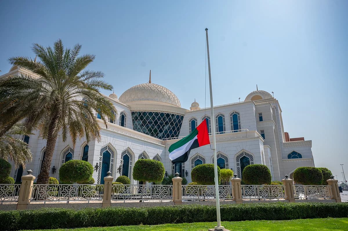 Sheikh Ahmed bin Rashid Al Maktoum with Dubai skyline and flags at half-mast.