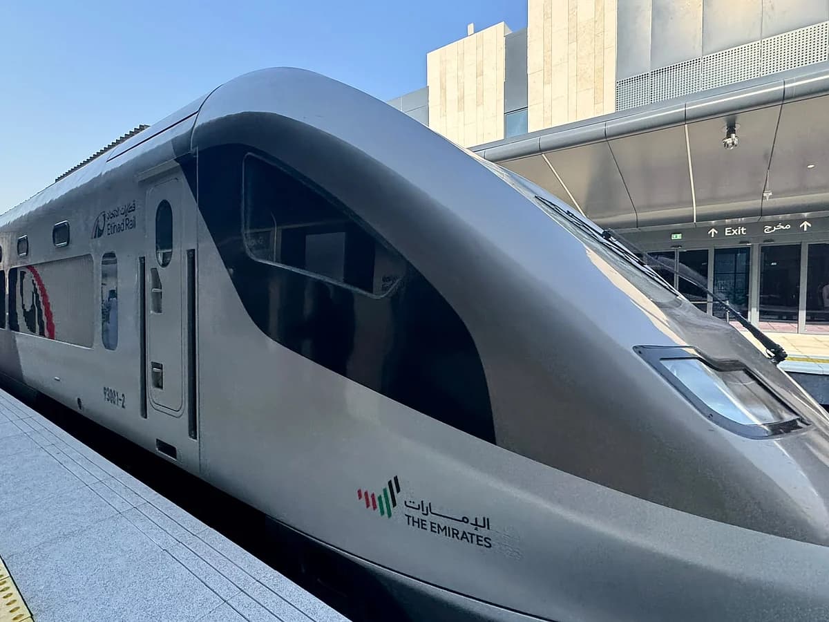 A modern Etihad Rail train traveling between Dubai and Abu Dhabi, showcasing the new passenger service.