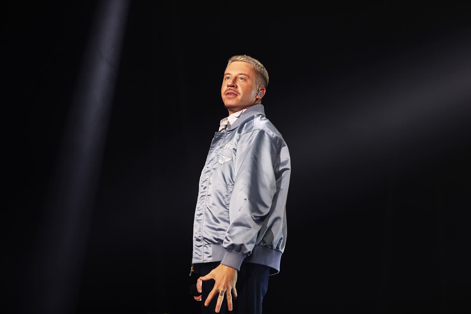 Macklemore passionately speaking on stage about his $1 million pledge to Palestinian relief organizations.
