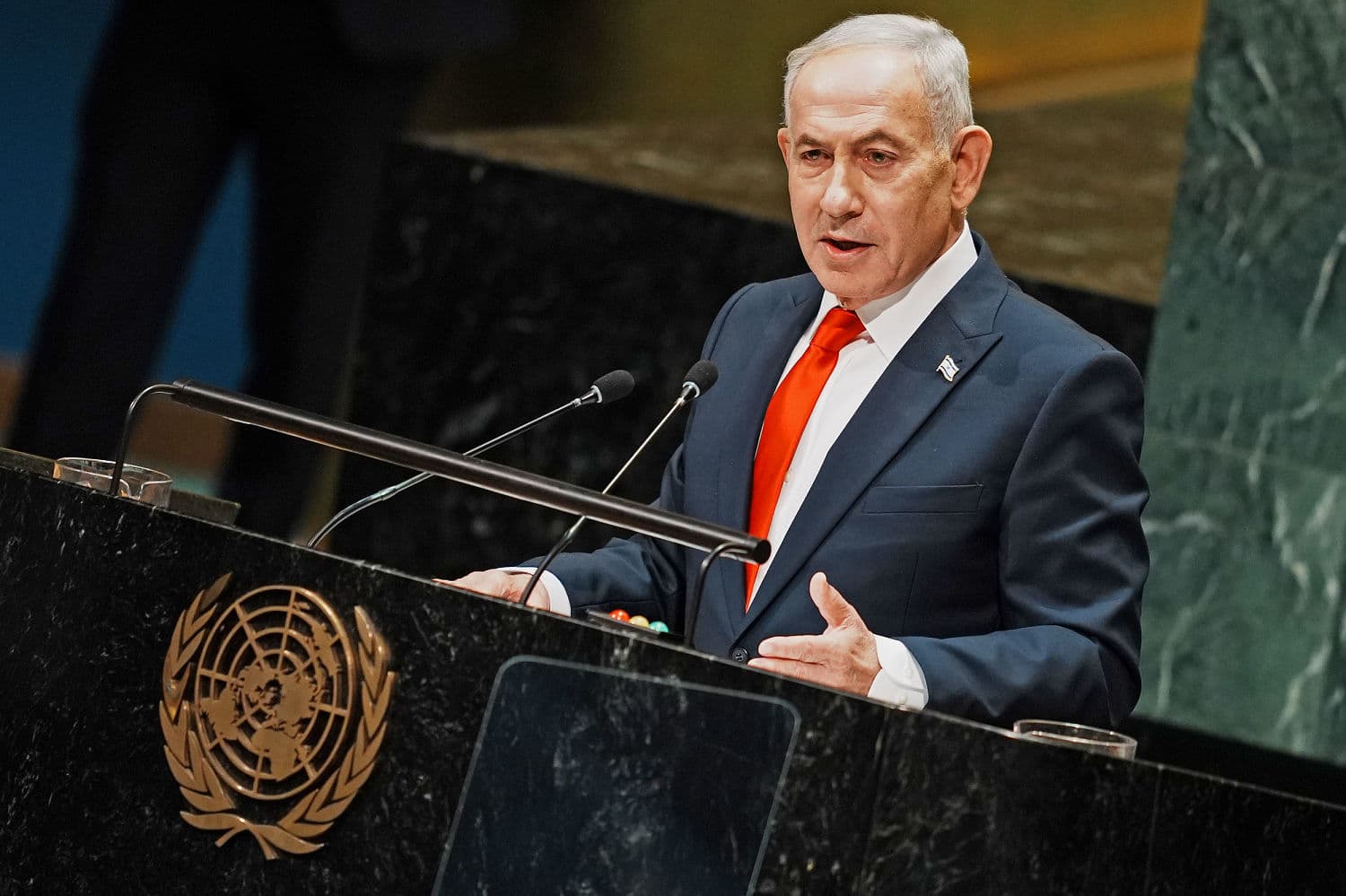 Netanyahu speaking at the UN with diplomats walking out, highlighting tensions over Gaza and Iran military operations.