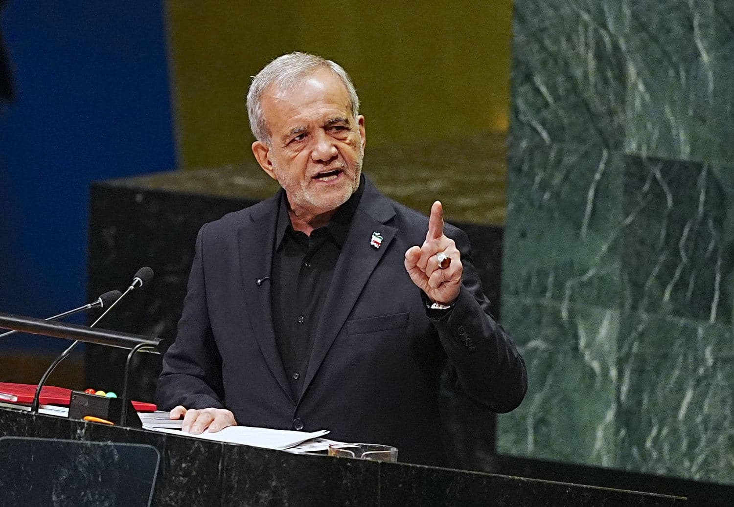 Iranian President Masoud Pezeshkian speaking at the UN General Assembly, addressing U.S. threats amid ongoing conflict.