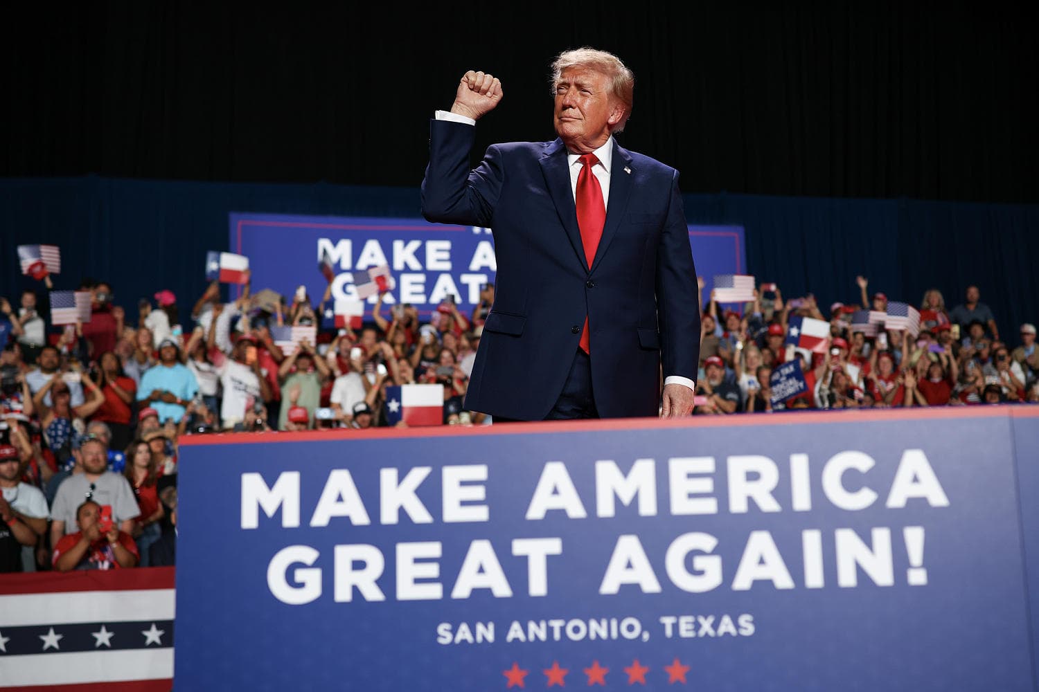 President Trump speaking at a rally with a backdrop of U.S. cities and Iran, highlighting his controversial remarks.