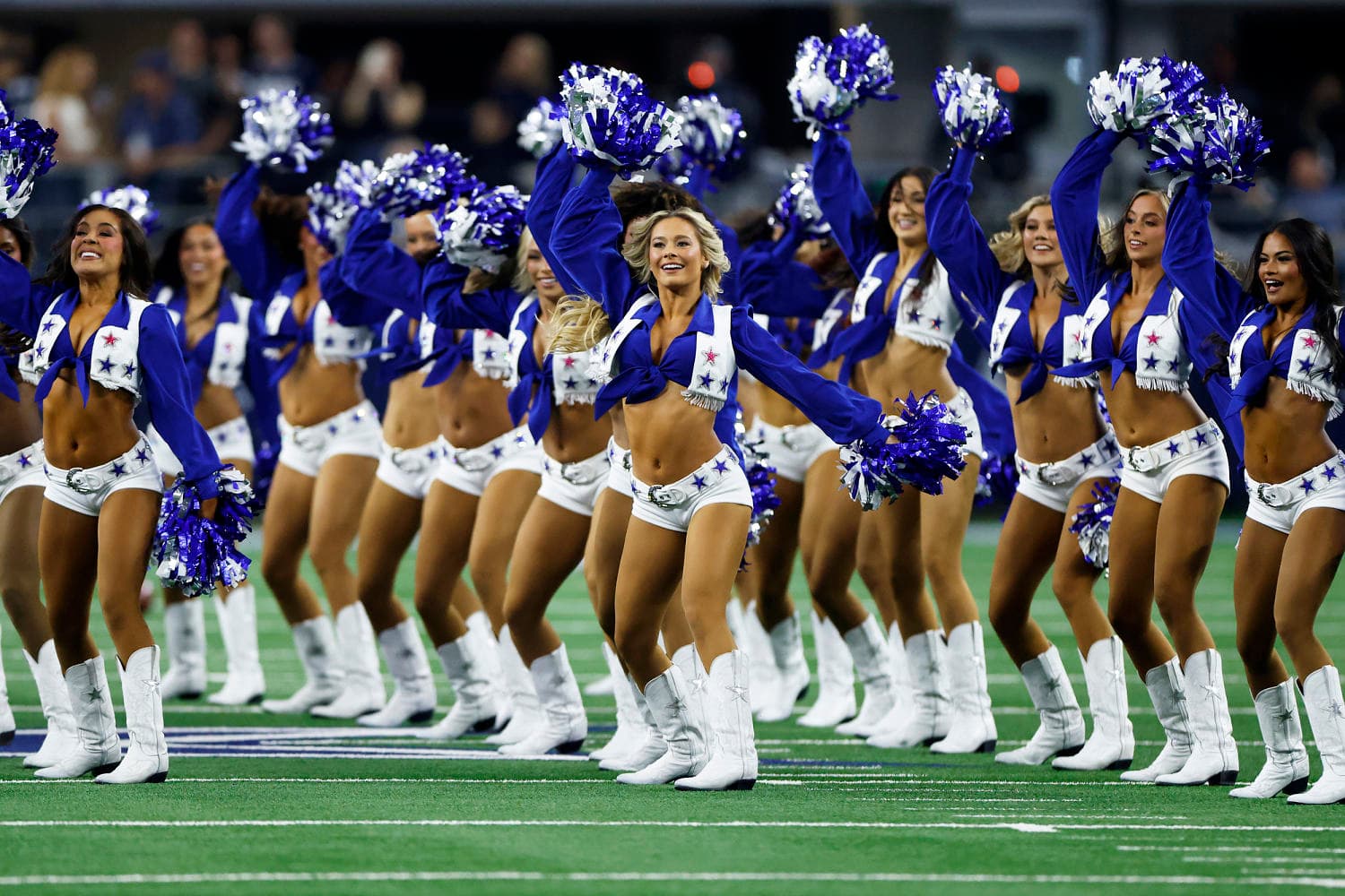 The Dallas Cowboys Cheerleaders formation seen from above on an NFL football field, highlighting pro sports labor evolution