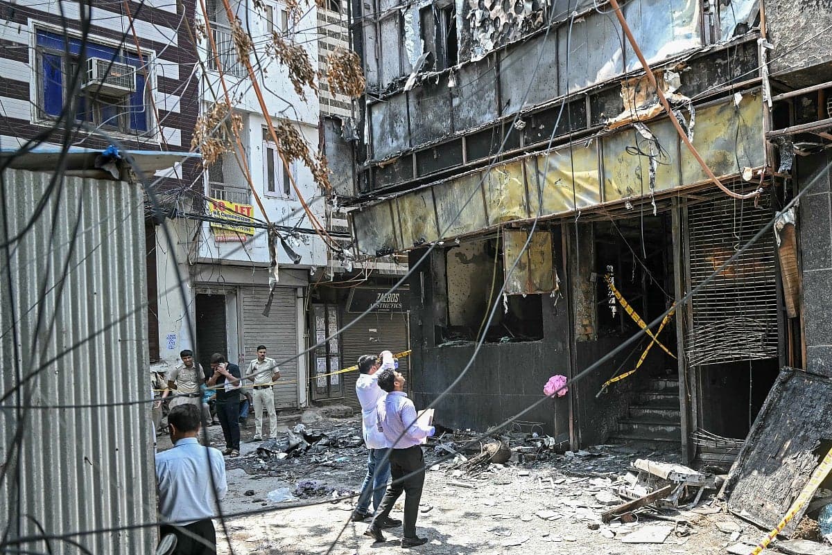 A somber scene depicting the aftermath of the hotel fire in New Delhi.
