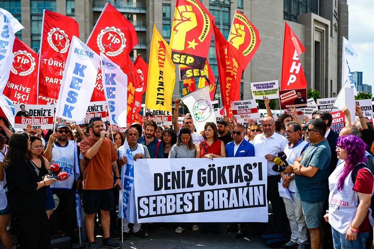 Deniz Goktas surrounded by supporters, representing the fight for free expression in Turkey.