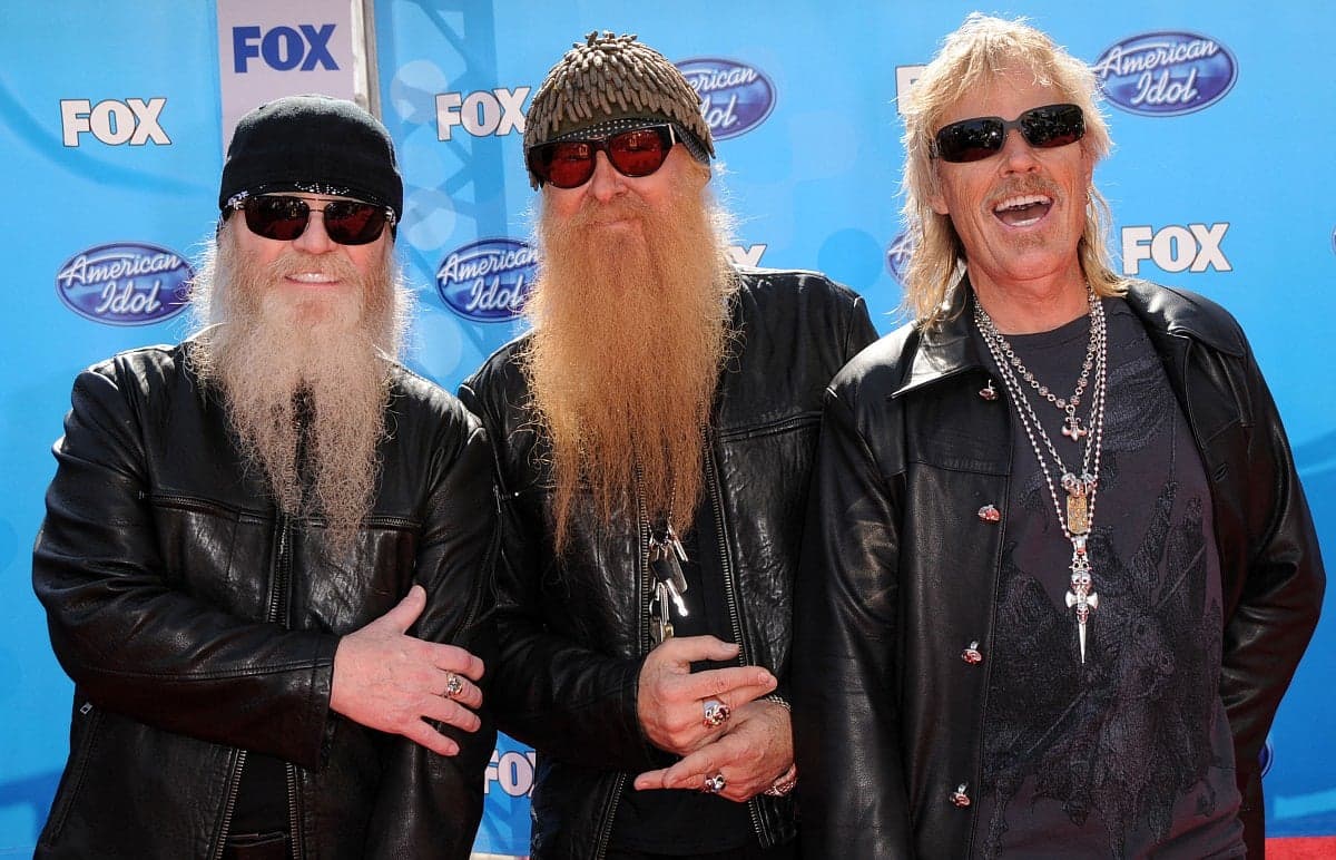 Frank Beard, the founding drummer of ZZ Top, performing on stage with the band.