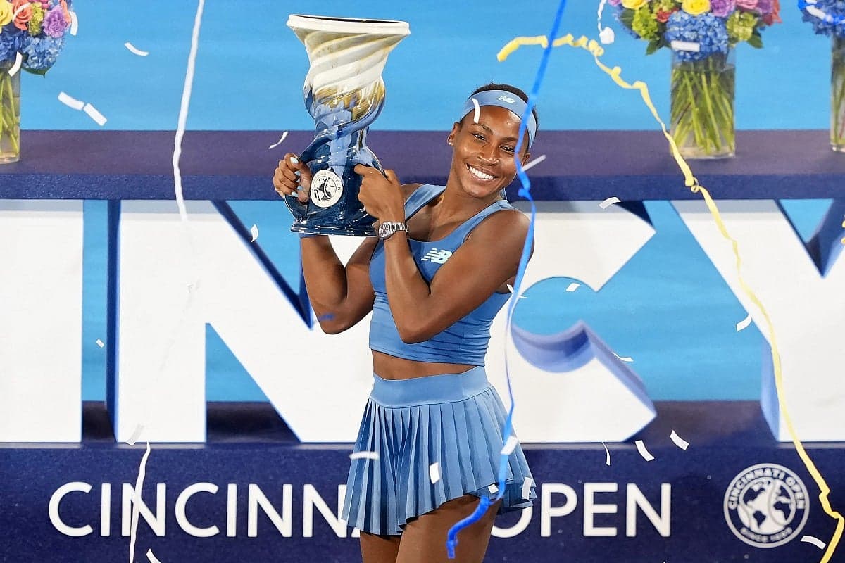 Coco Gauff celebrating her Cincinnati Open victory, holding the trophy with a bright smile.