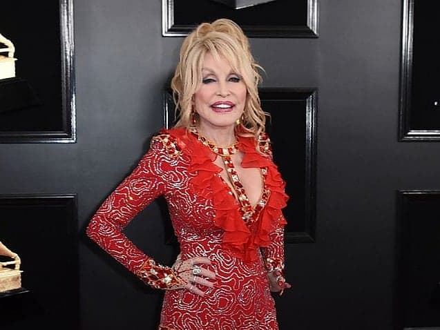 Dolly Parton with a guitar, symbolizing her legacy in music and philanthropy.