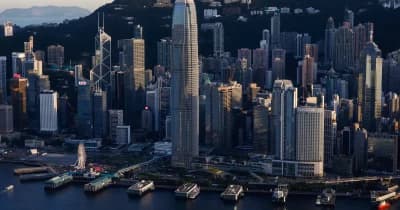 Hong Kong skyline with financial district buildings and stock market graphs.