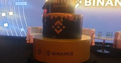 Binance logo with a backdrop of cryptocurrency symbols and regulatory icons.