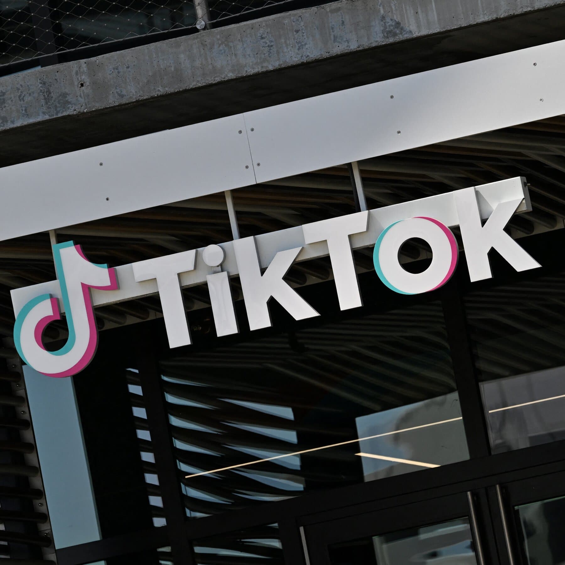 TikTok logo with a backdrop of a closed office building