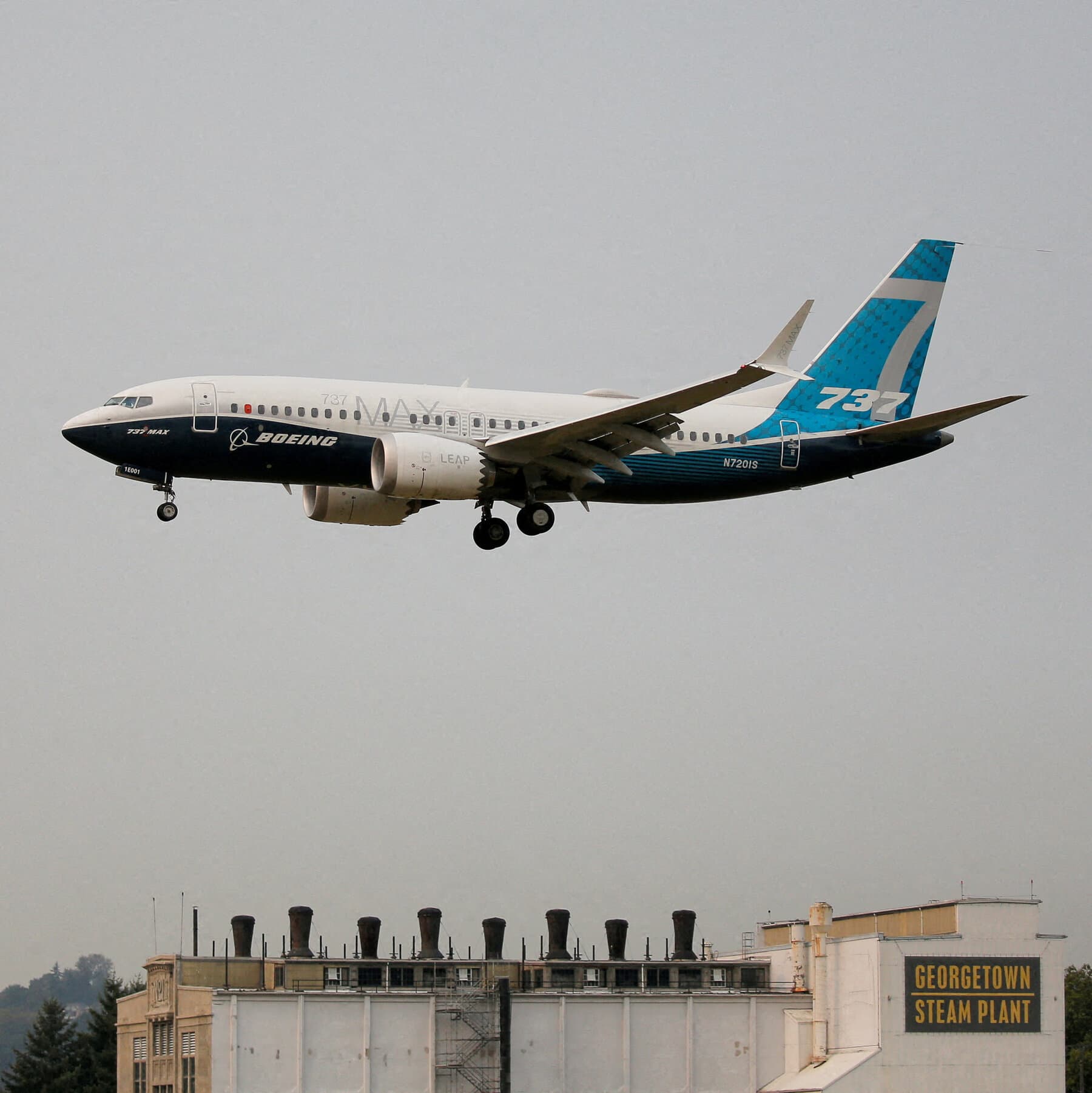Boeing 737 MAX 7 aircraft in flight against a clear blue sky.