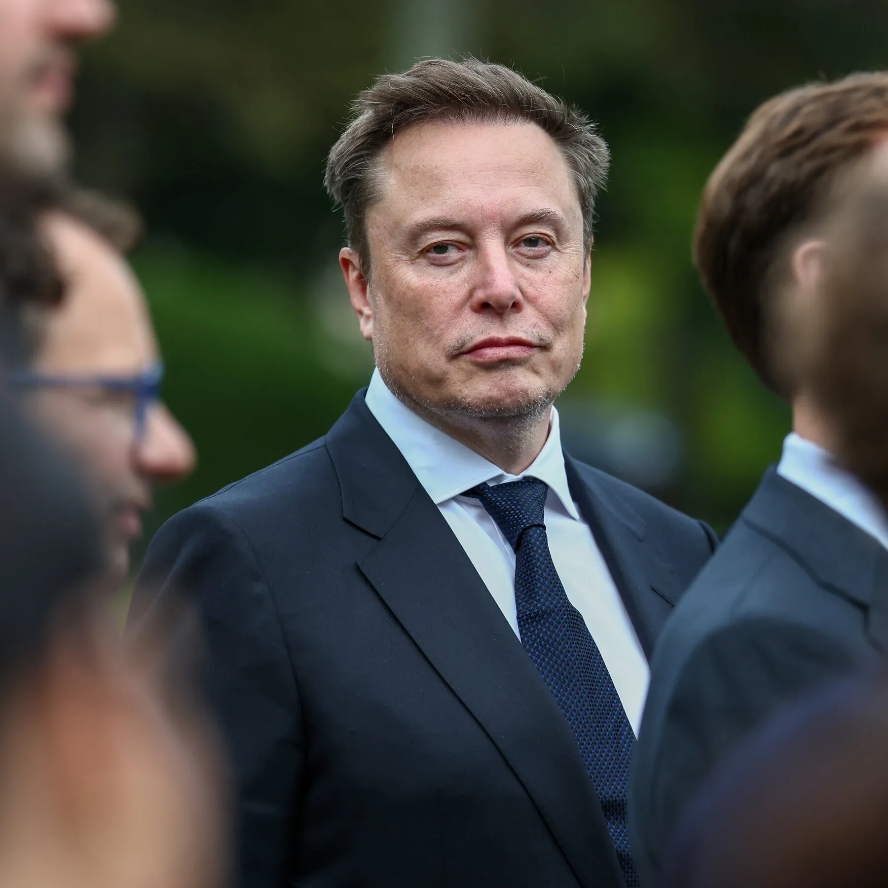 Elon Musk with a SpaceX rocket and children, representing the share distribution initiative.