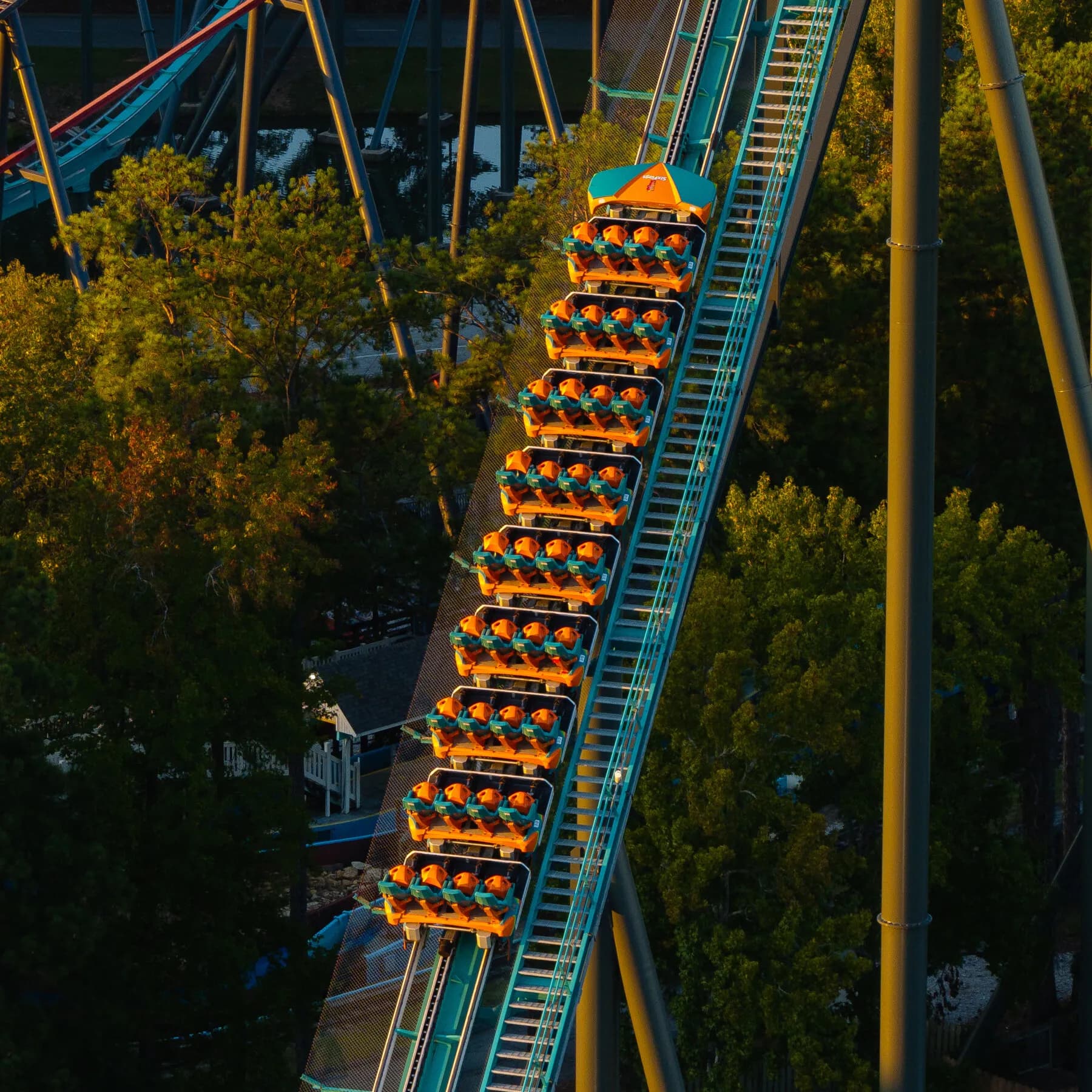 Minimalist graphic of a roller coaster lap-bar restraint and the number nine highlighting Six Flags safety retrofits
