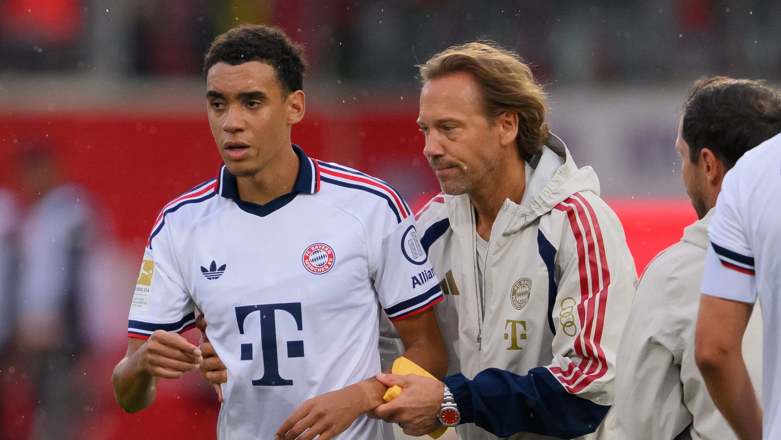 Jamal Musiala playing for Bayern Munich with a health alert overlay about his neurological diagnosis.